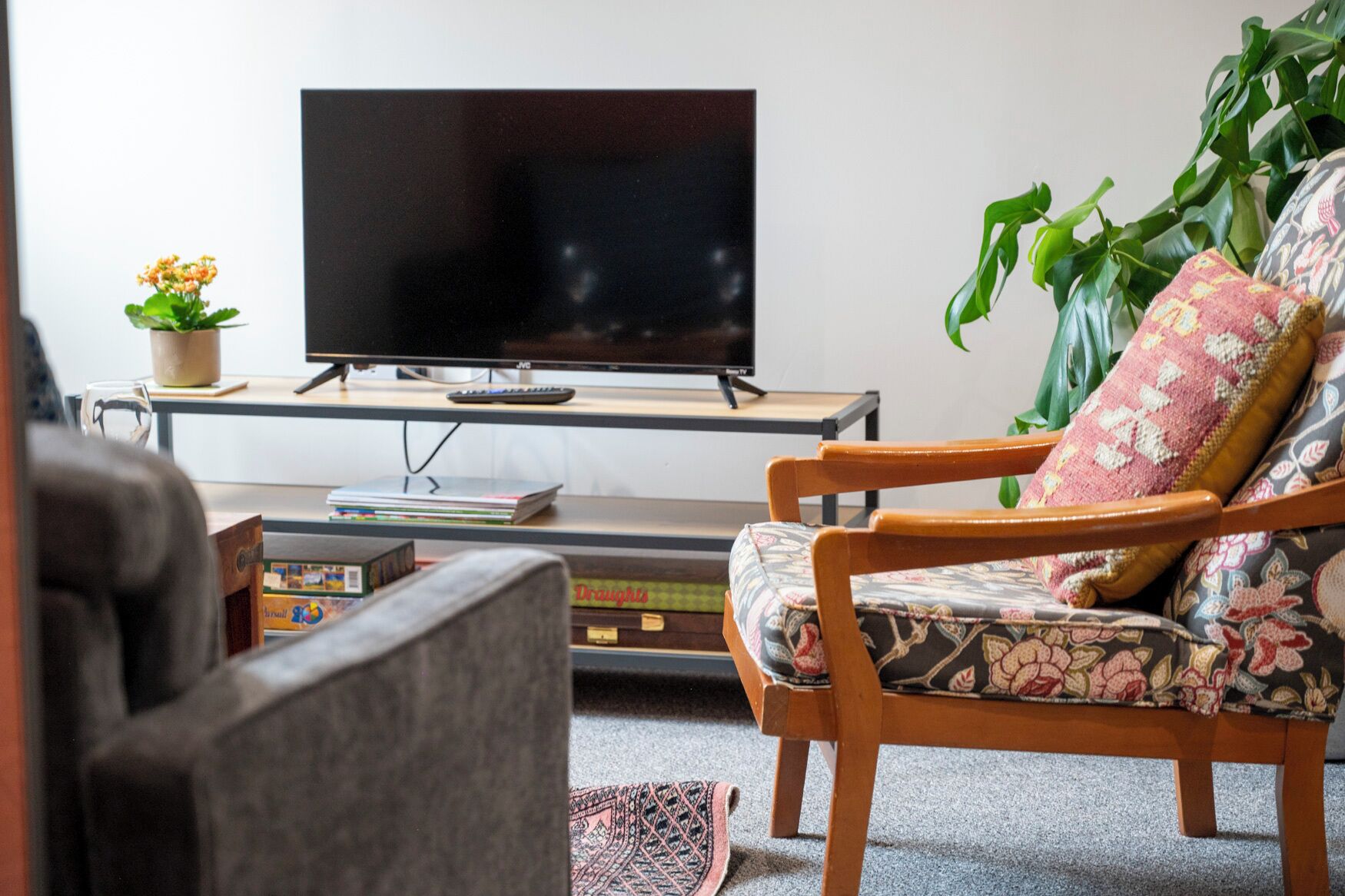 A living room with a television, a sofa, a coffee table, and a bookshelf.