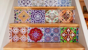 Un escalier avec des carreaux colorés et à motifs, ainsi que des marches en bois.