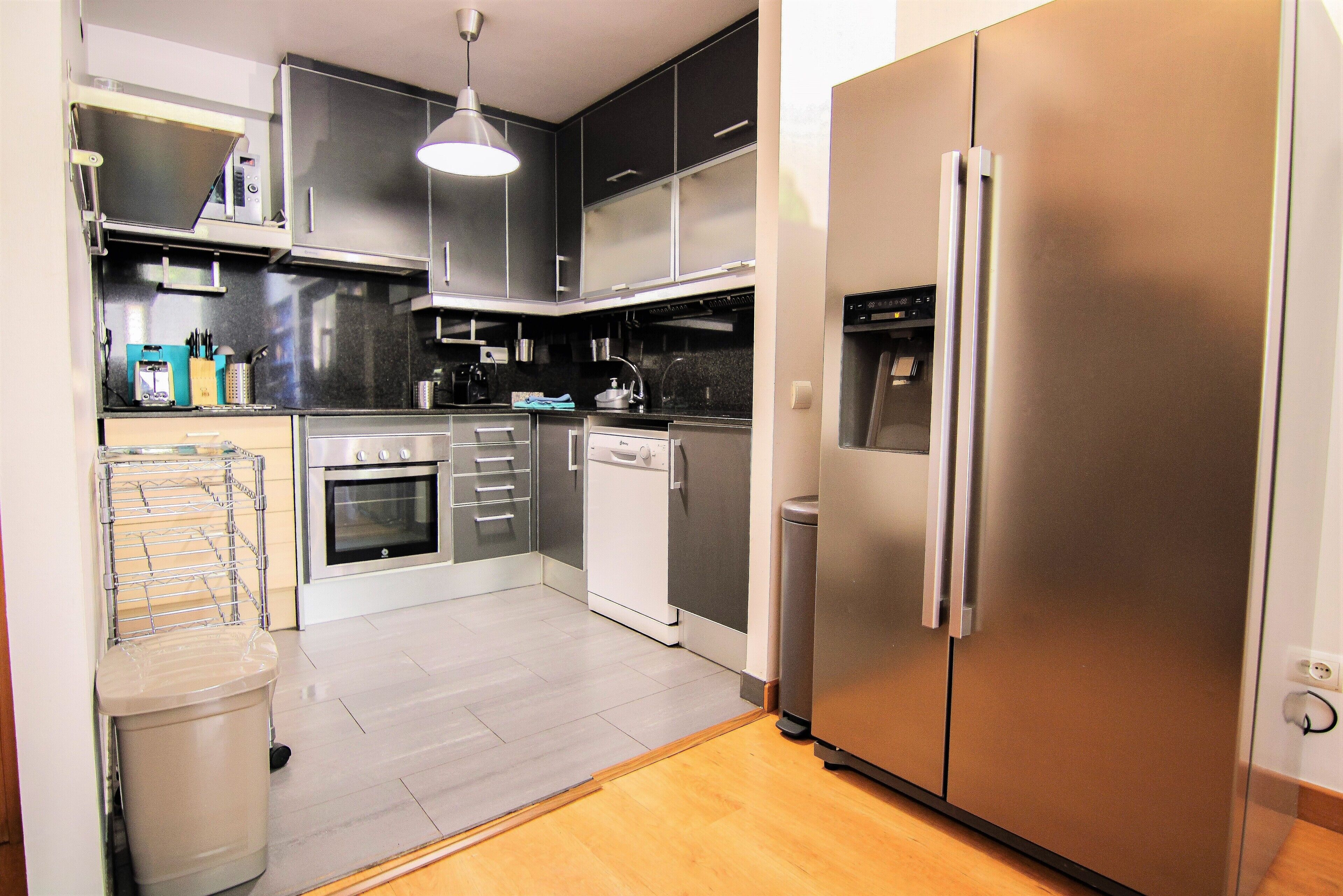 A modern kitchen with stainless steel appliances, a built-in oven, and a dishwasher.