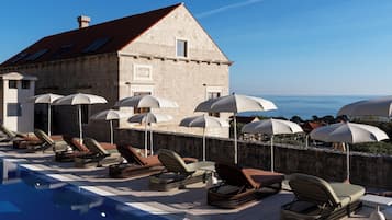 Una piscina al aire libre de temporada, sombrillas