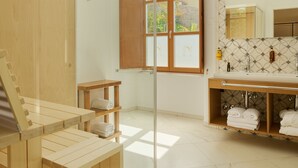 A modern bathroom with a wooden sauna, a large mirror, and a window with wooden shutters. - Palace Natali (Dubrovnik)