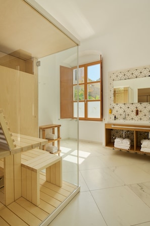 Un baño moderno con sauna de madera, un espejo grande y una ventana con contraventanas de madera.