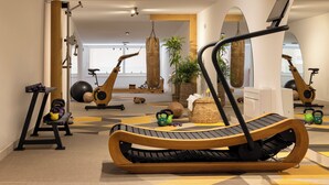 A modern gym with exercise equipment, a treadmill, and a mirror. - Palace Natali (Dubrovnik)