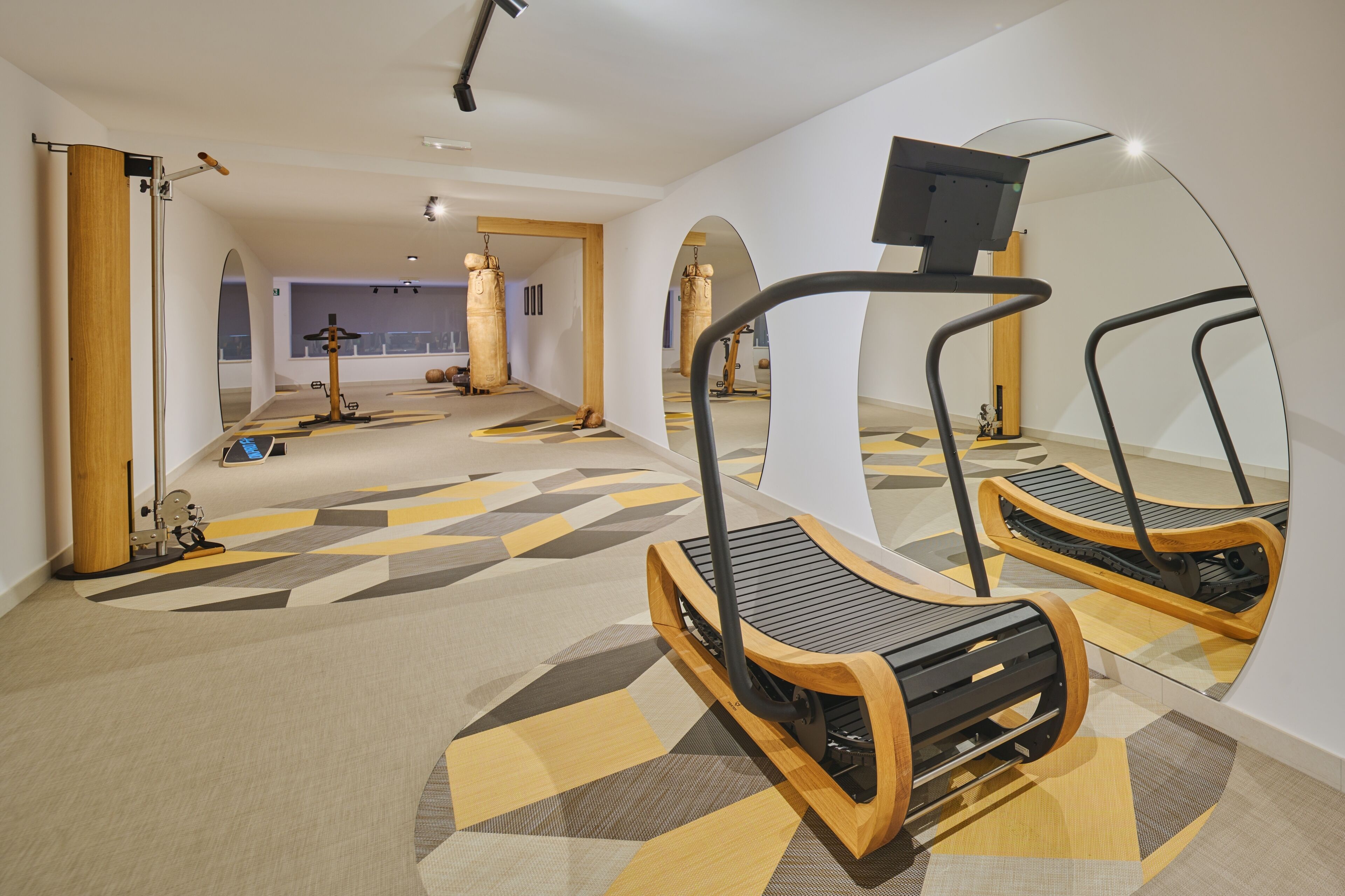 A modern gym with treadmills, exercise equipment, and a large mirror.