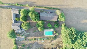 An aerial view of a property with multiple buildings, a swimming pool, and surrounding greenery. - Gîte Tranquille Avec Piscine Partagée (Crespin)