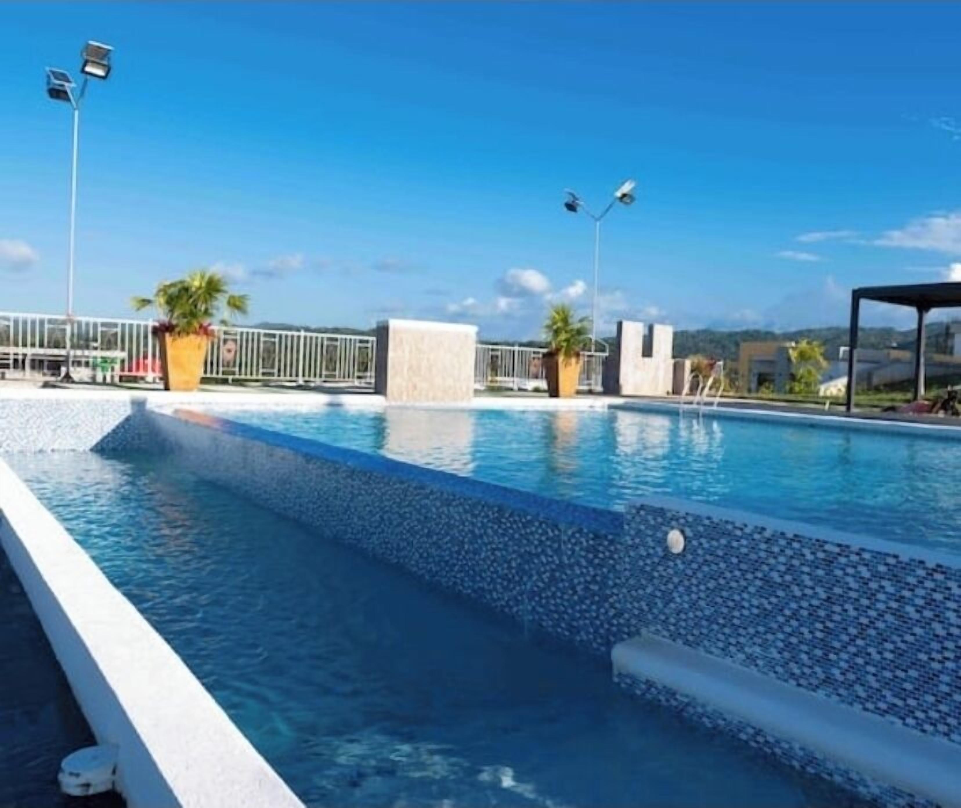 A swimming pool with a clear blue sky in the background.