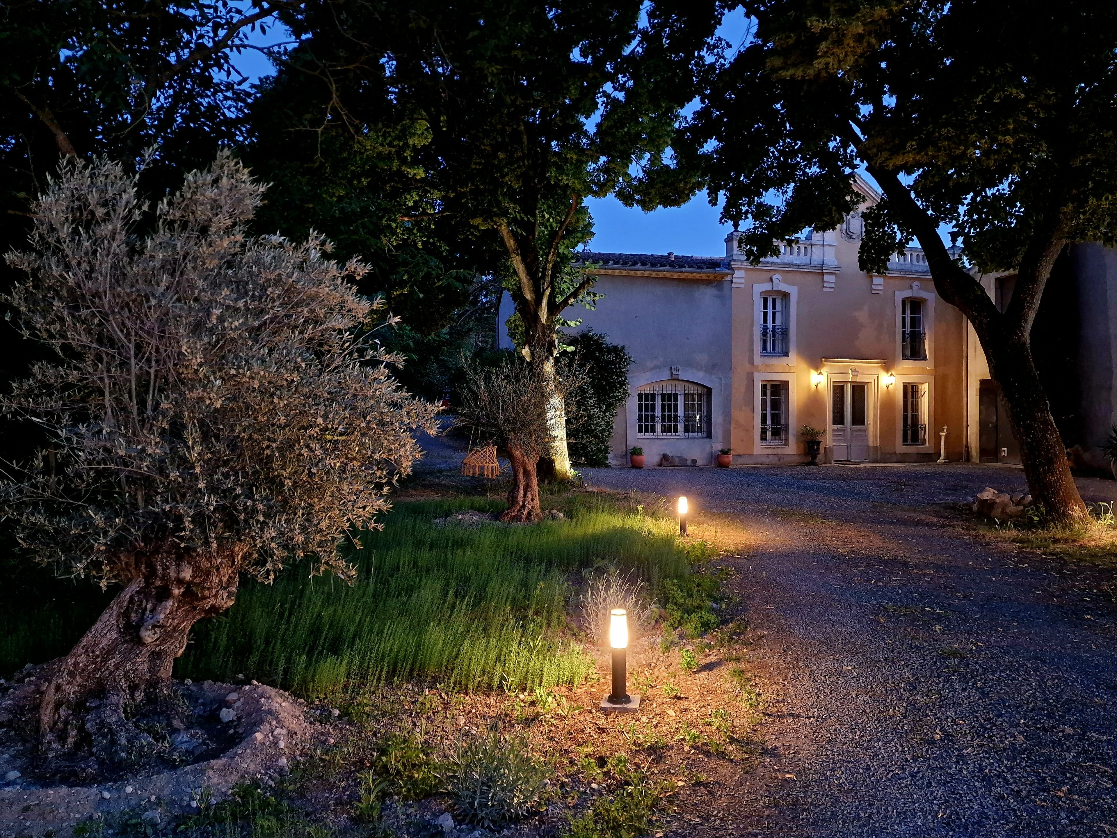 A building with a gravel driveway and a well-maintained garden.