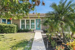 A residential property with a front yard, a pathway leading to the entrance, and a variety of plants and shrubs.