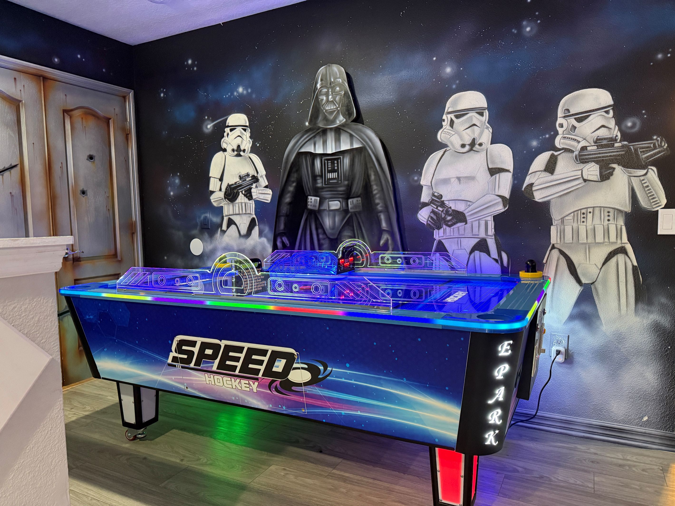 A Speed Hockey table with Star Wars-themed wall art.