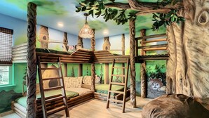A children's playroom with a tree-themed bunk bed, ladders, and a hanging light fixture. - Star Wars 8BR | Arcade Game Rm | 2 Theaters | Pool (Kissimmee)