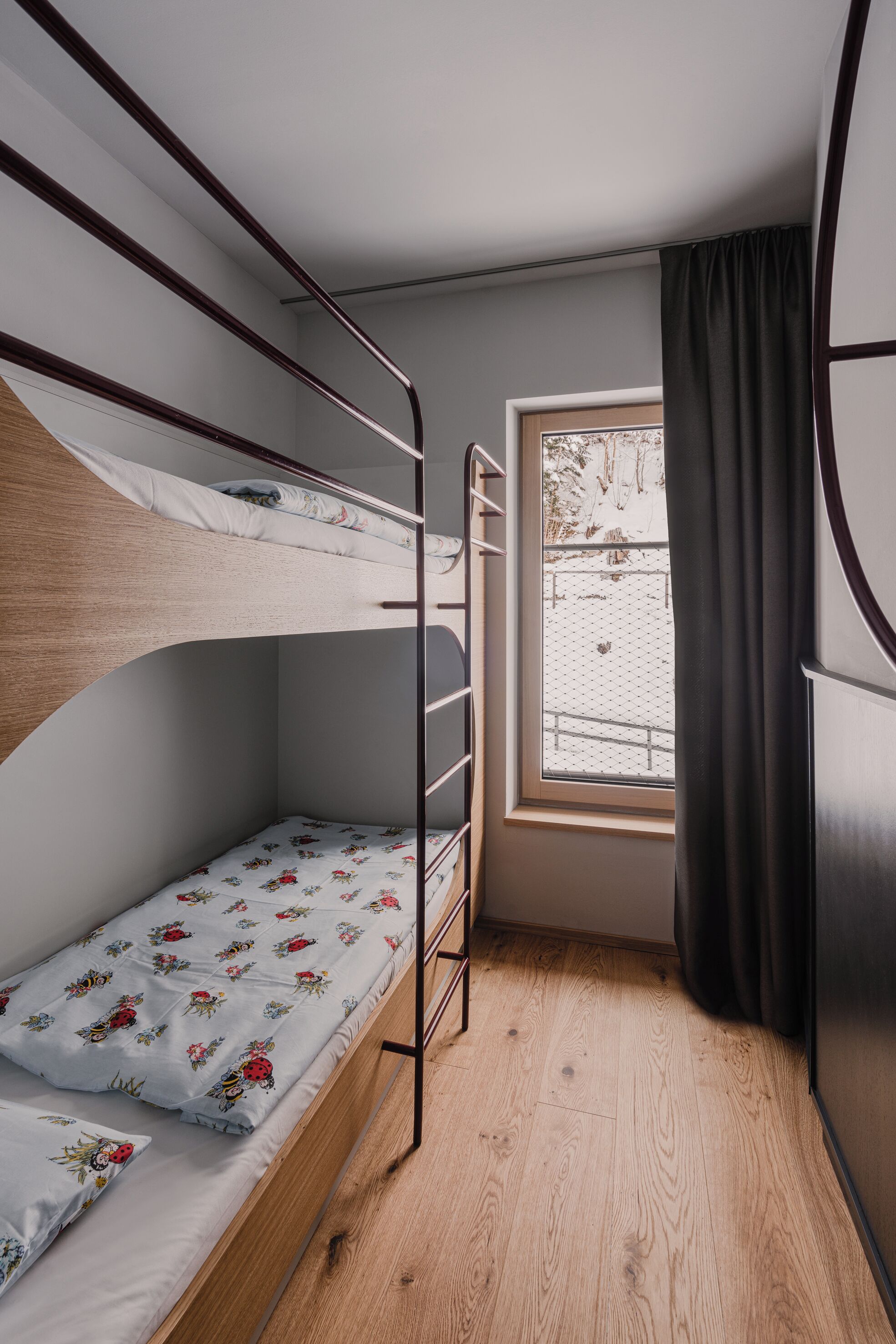 Dormitorio con literas, una ventana y una cortina.
