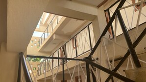 A multi-level building with a staircase and metal railings. - leleshwa inn (Kitengela)