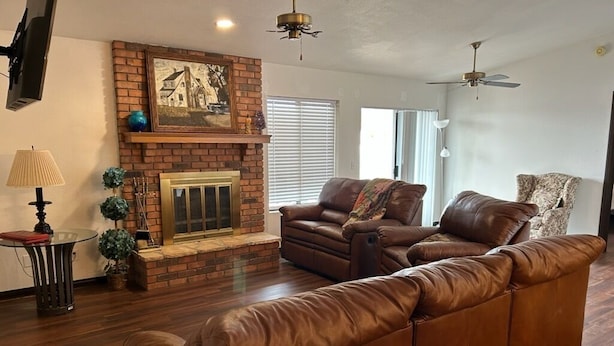 A living room with a fireplace, leather sofa, and a television. - Sun Lakes Country Club (Sun Lakes)