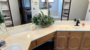 A modern bathroom with a large mirror, a sink, and wooden cabinets. - Sun Lakes Country Club (Sun Lakes)