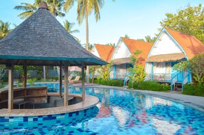 A swimming pool with a tiled edge, a gazebo, and thatched-roof huts with blue trim. - The MG Villa & SPA (Penida Island)