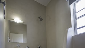 A compact bathroom with a white sink, mirror, and shower. - Theros Retreat (Kefalonia)