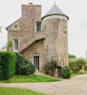 Experience the charm of this historic building, featuring a grand arched entrance and a picturesque lawn.