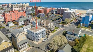 A coastal town with a prominent red building labeled 'Condo' and various other residential and commercial buildings. - Newly Remodeled Condo - Steps to Beach & Boardwalk (Ocean City)