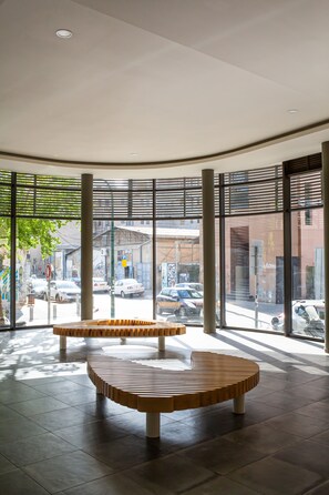A spacious lobby with large windows offering views of the street and parked cars. - Cozy 2BDR with Parking  (Tel Aviv)