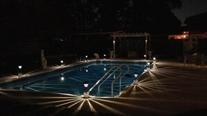 A swimming pool with a pergola and lights around it. - Relax by the sea! Three bedroom home with pool awaits you near Destin Beaches. (Fort Walton Beach)