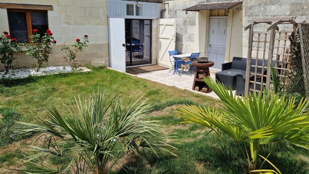 A courtyard with a patio area, a door, and a small garden with plants. - The Wine Press (Turquant)