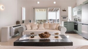 Uma sala de estar moderna com um sofá, uma mesa de centro e vista para o exterior.