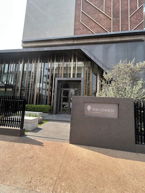 A modern building entrance with a nameplate reading 'THE LENNOX' and a gated driveway. - Luxurious One bedroom Apartment at The Lennox Airport Residential Accra (Accra)
