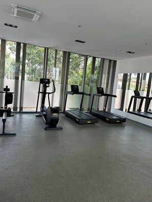 Une salle de sport équipée de tapis de course, d’un appareil elliptique et d’autres équipements d’exercice.