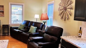 A living room with a leather sofa, a red lamp, and a decorative wall piece. - Home Near USC, Perfect for Families & Graduations - Deja Blues  (West Columbia)
