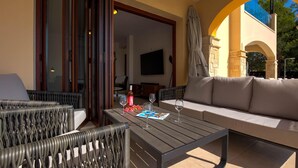 An outdoor seating area with wicker chairs, a sofa, and a table set with wine glasses and a bottle. - Villa TA01 Ouranos - Three Bedroom Villa, Sleeps 6 (Kouklia)