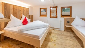 Una stanza in legno con un letto, due comodini e una finestra.