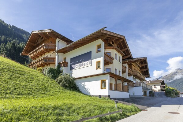 A traditional chalet-style building with a sign reading "Stuba". It features wooden balconies, a sloped roof, and is situated on a hillside with a mountain backdrop. - Apartment Neustift Near Stubai Glacier (Neustift Im Stubaital)