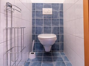 A small, modern bathroom with a toilet, a hand dryer, and a toilet brush. - Apartment Neustift Near Stubai Glacier (Neustift Im Stubaital)