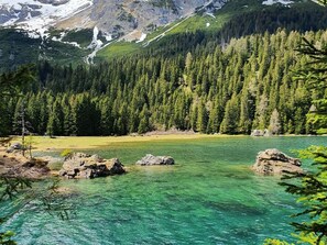 A clear mountain lake surrounded by dense forest and rocky terrain. - Lovely Apartment in the Stubai Valley (Neustift Im Stubaital)