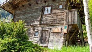 A rustic wooden cabin with a balcony, a wooden door, and a window. - Beautiful Apartment in a top Location in the Zillertal (Hainzenberg)
