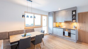 A modern kitchen with grey cabinets, a wooden countertop, and a built-in oven. - Beautiful Apartment in a top Location in the Zillertal (Hainzenberg)