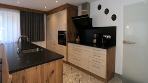 Una cocina moderna con una isla central, horno empotrado y cafetera.