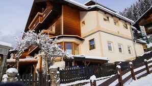 A multi-story building with a wooden facade, large windows, and a snow-covered exterior. - Apartment in Hippach With Mountain Views (Hippach)