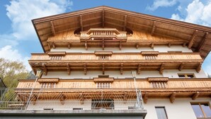 Un immeuble à plusieurs étages, doté d’une façade en bois, de balcons et surplombant un ciel dégagé.