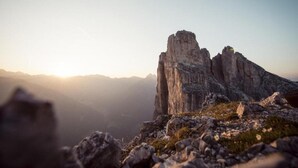Paisagem montanhosa acidentada com formações rochosas imponentes e céu claro.