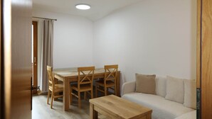A room with a wooden dining table and chairs, a sofa, and a small wooden side table. - Apartment Neustift Near Stubai Ski Lift (Neustift Im Stubaital)