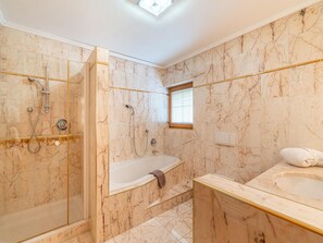 A bathroom with a glass-enclosed shower, a freestanding bathtub, and a marble-tiled vanity with a sink. - Charming Holiday Home in Maurach am Achensee (Eben am Achensee)