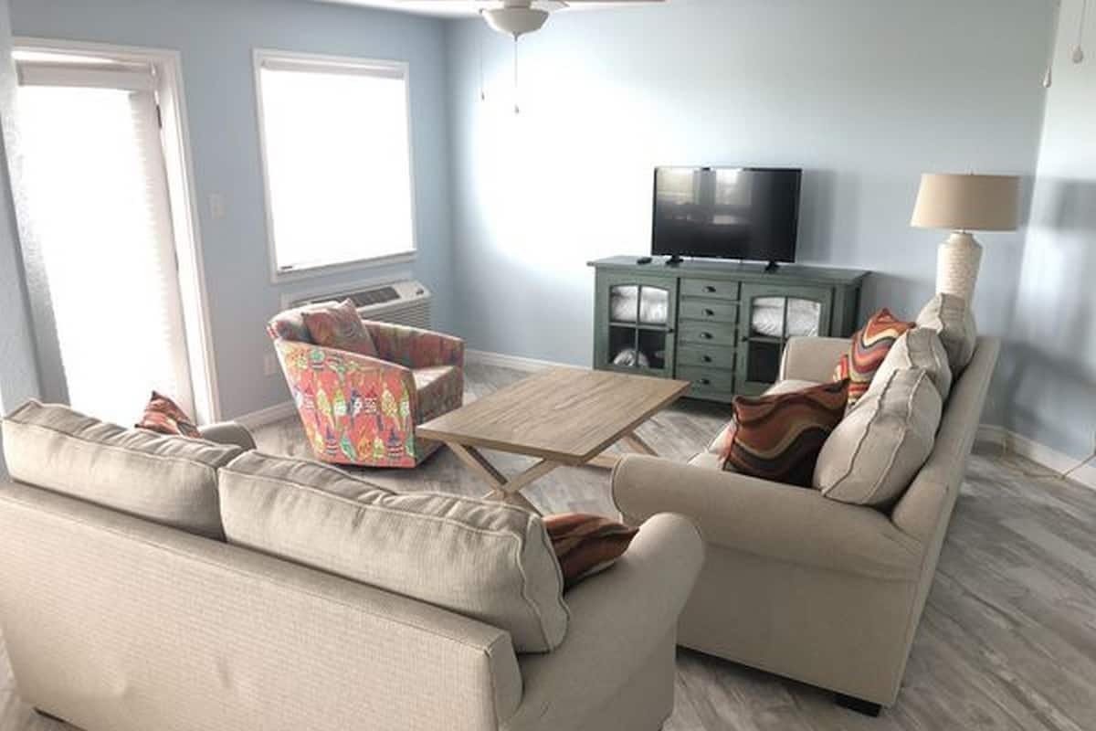A living room with a sofa set, a coffee table, a TV, and a cabinet.