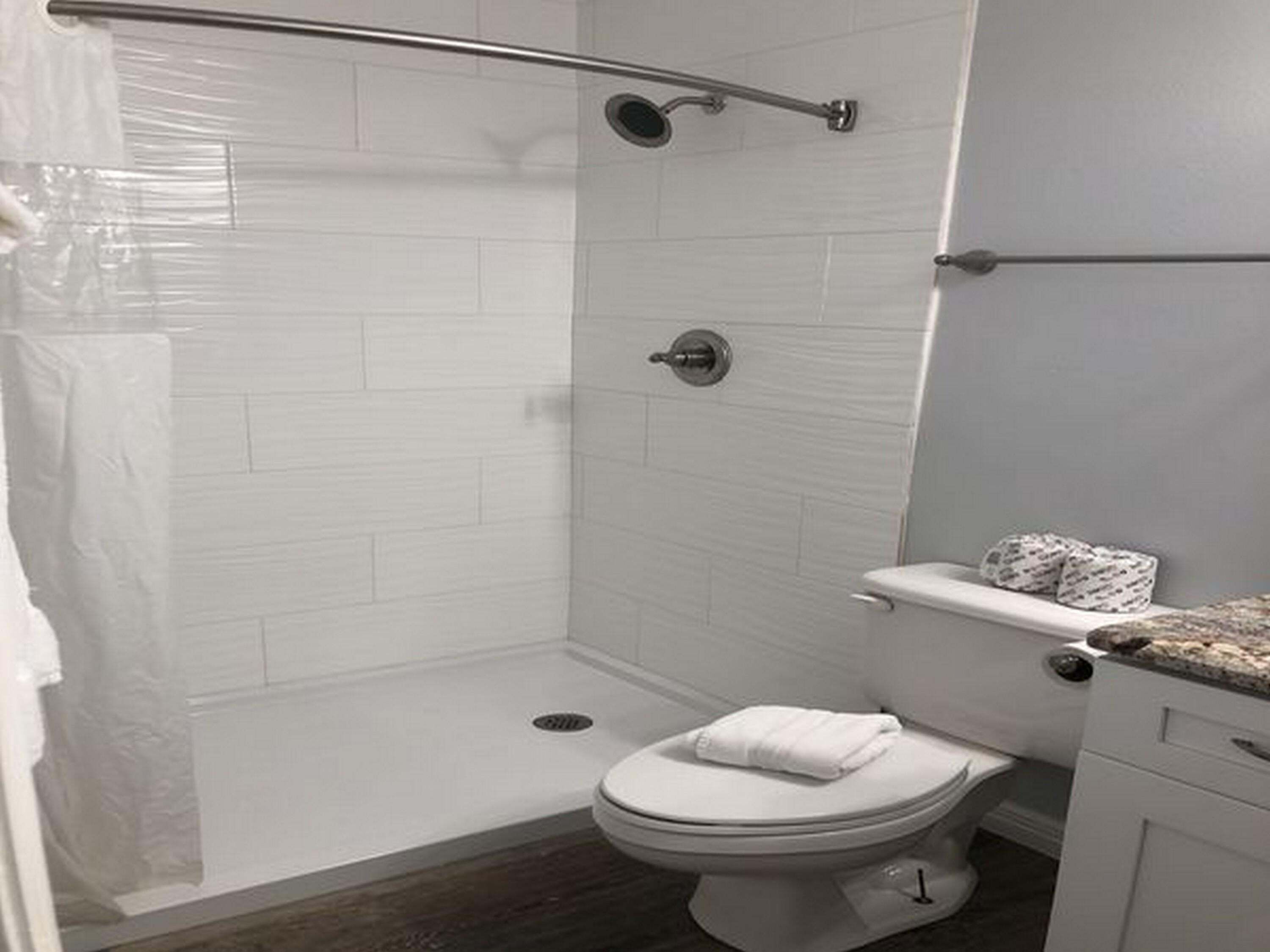 Un bagno con doccia, WC e lavandino.