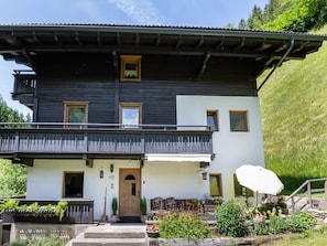 A two-story building with a balcony, a wooden door, and a small window on the upper floor. - Chalet in Tirol by Zillertal Ski Slopes (Brandberg)