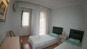 Une chambre avec deux lits, un bureau et une chaise.
