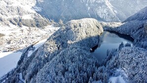 A snow-covered mountainous landscape with a lake and a winding road. - Apartment in Neustift Near Ski Lift (Neustift Im Stubaital)