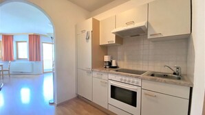A modern kitchen with white cabinets, a built-in oven, a sink, and a coffee maker. - Apartment in Neustift Near Ski Lift (Neustift Im Stubaital)