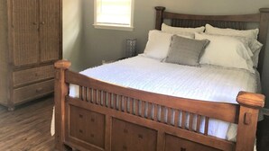 Ein Schlafzimmer mit einem hölzernen Bett, einem Nachttisch und einem Kleiderschrank.