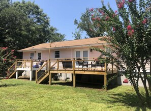 A two-story house with a wooden deck and a covered patio area.